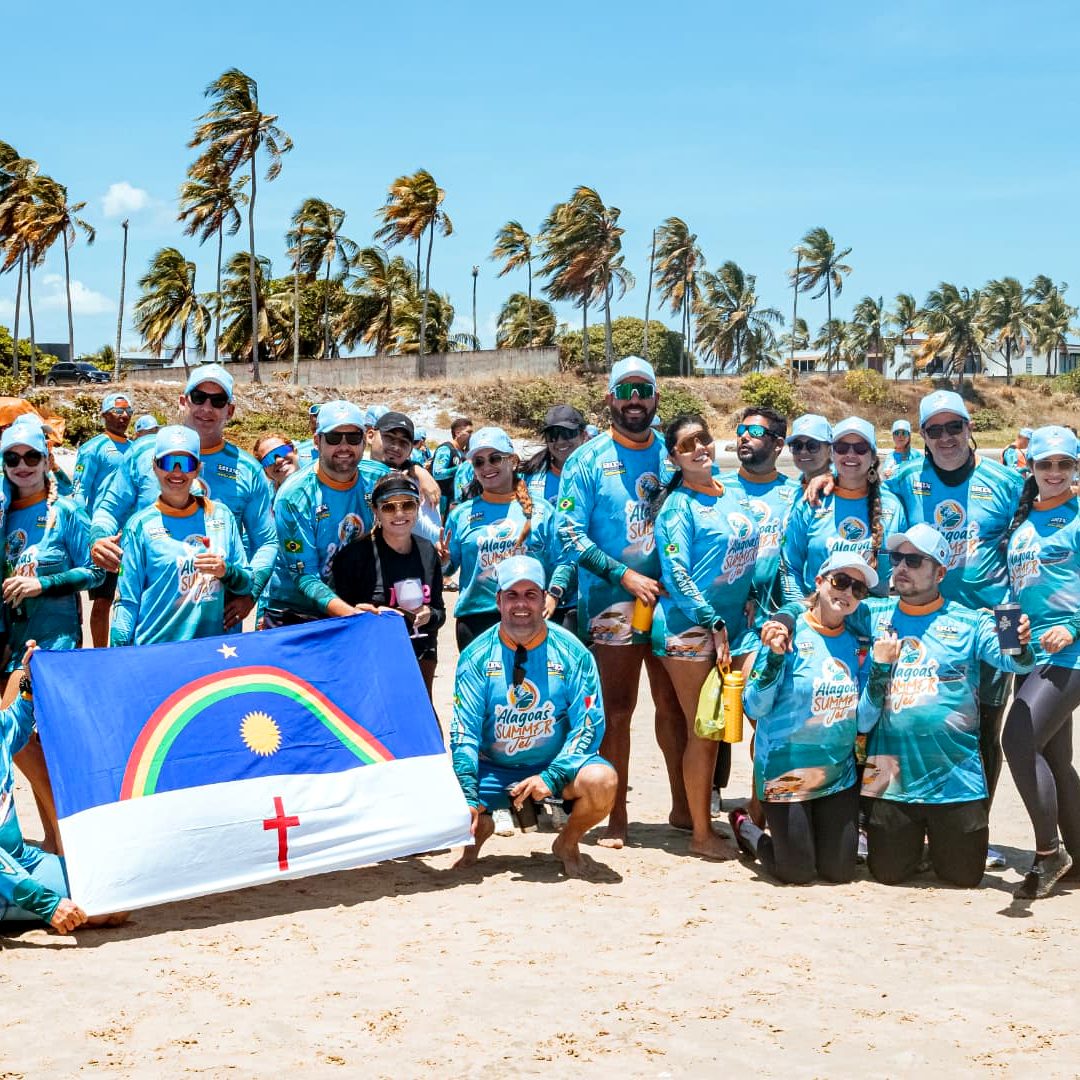 Grupo de participantes com camisas oficiais na praia